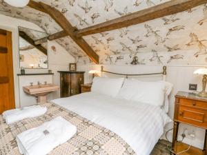 a bedroom with a large white bed and a sink at Ty Sinsir in Crickhowell