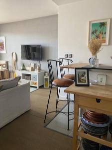 a living room with a table and a tv at Bel appartement cosy proche de Paris in Saint-Maur-des-Fossés
