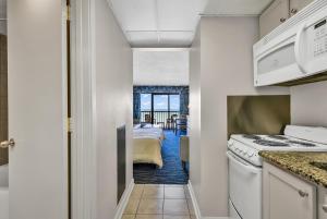 um quarto com uma cozinha e um quarto com uma cama em Windsurfer Hotel em Myrtle Beach