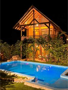 a swimming pool in front of a house at night at Canto del Río Lodge in Tarapoto