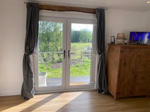 a sliding glass door with a view of a yard at Devon River Glamping Pods in Alloa