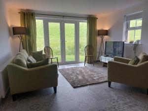 a living room with two couches and a large window at The Cove in Aughnacloy