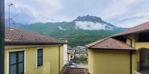 Taceno的住宿－La corte di via Chiarello，从两栋建筑中可欣赏到山景