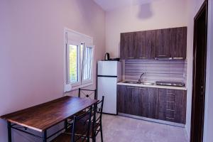 a kitchen with a table and a white refrigerator at Harmony Apartments in Larisa