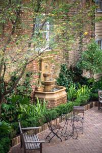 a park with two benches and a fountain at Zero George Hotel in Charleston