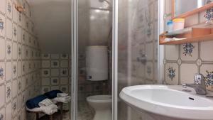 La salle de bains est pourvue d'une douche, d'un lavabo et de toilettes. dans l'établissement Loft64, à Alba