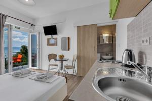 a bathroom with a tub and a kitchen with a view at View Blue Apartments in Brela