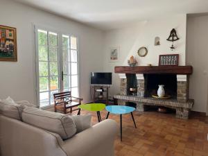 a living room with a couch and a fireplace at Les Stoechades in Rayol-Canadel-sur-Mer