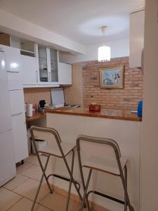 a kitchen with two chairs at a counter at Varkiza Seaside Apts in Varkiza