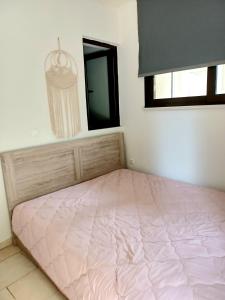 een bed in een kamer met een roze matras bij Varkiza Seaside Apts in Varkiza