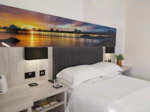 a bedroom with a large painting on the wall at The Rosedene in Llandudno