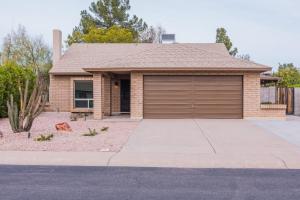a house with a garage in front of it at Cozy Quiet two story home pool outdoor entertaining bbq in Chandler