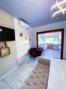 a bedroom with a bed and a living room at Pousada Vila Velha in Pirenópolis