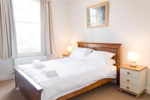 a bedroom with a bed with white sheets and a window at York Terrace Apartments - Norwich City in Norwich