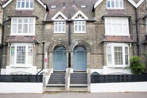 a large brick building with blue doors and stairs at York Terrace Apartments - Norwich City in Norwich