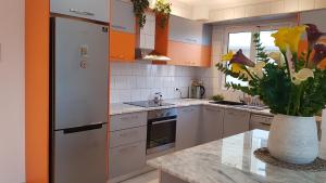 een keuken met een koelkast en een vaas met bloemen bij Saranda sea view apartment in Sarandë