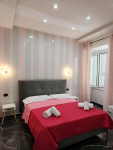 una camera da letto con un letto rosso con due asciugamani di Historical Center a Napoli