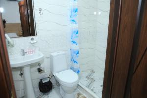 Baño blanco con aseo y lavamanos en HOTEL MEHRIBON, en Samarkand