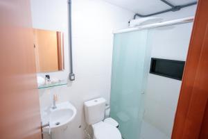 a bathroom with a toilet and a sink and a shower at Local Hostel & Suites Manaus in Manaus +92 photos