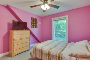 1 dormitorio con paredes rosas, 1 cama y ventana en Cozy Old Forge Home with 2 Porches, Fire Pit, Hot Tub, en Old Forge
