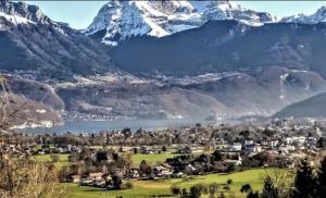 Quiet Studio in a House in Sevrier Annecy Lake very close to the lake في سفرييه: اطلاله على مدينه فيها جبل مغطى بالثلوج