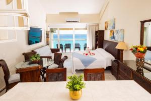 2 Story Oceanfront Penthouses on Cancun Beach! في كانكون: غرفة معيشة مع سرير وغرفة معيشة مع المحيط