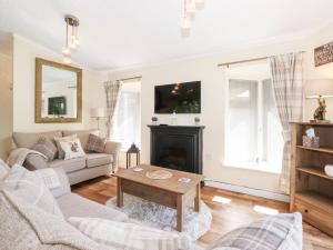 uma sala de estar com um sofá e uma lareira em Nutkins Lodge em Windermere