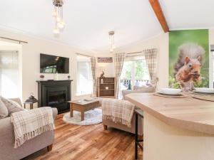 uma sala de estar com uma cozinha e uma sala de estar com uma mesa em Nutkins Lodge em Windermere