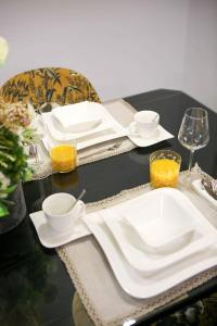 una mesa negra con platos blancos, tazas y vasos en New & Luxury apartment Tony en Split