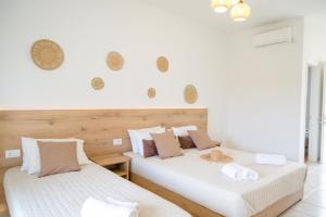 two beds sitting next to each other in a room at Tropical Apartments in Alykes