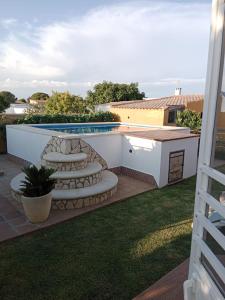 podwórko z basenem i patio z krzesłami w obiekcie Chalet Villa Terry w mieście Chiclana de la Frontera