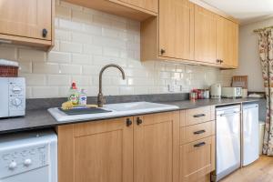 a kitchen with wooden cabinets and a sink at The Granary in Beaminster