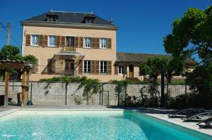 a house with a swimming pool in front of a house at Le Clos des Tanneurs in Taponas