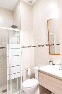 a white bathroom with a toilet and a sink at La Gloria in Cádiz