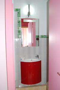 baño con lavabo rojo y espejo en Hôtel Azur, en Niza