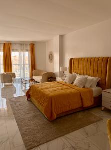 a bedroom with a large bed and a living room at Residence INFINITE in Dakar