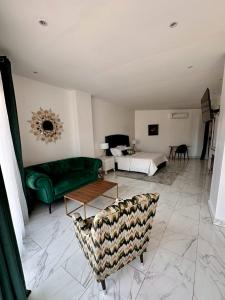 a living room with a green couch and a bed at Residence INFINITE in Dakar