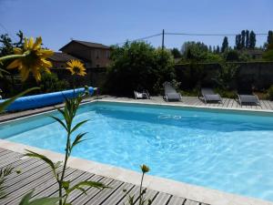 a swimming pool with two lounge chairs next to it at Le Clos des Tanneurs in Taponas +5 photos