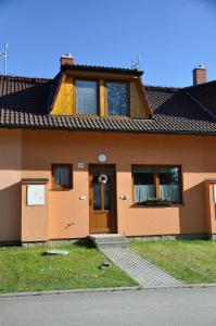 uma casa com uma porta castanha e janelas em Rekreace na Lipně em Frymburk