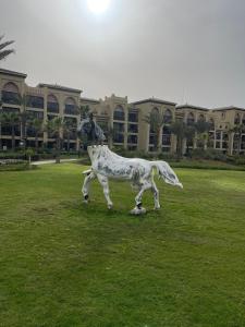 a statue of a cow standing in a field at La Remaz 35 in El Jadida