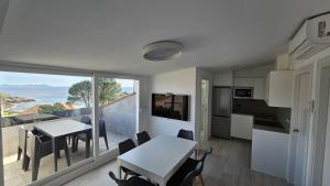 een keuken en eetkamer met een tafel en uitzicht bij Apartamentos Coral Do Mar I in Portonovo