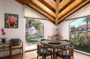 a dining room with a table and chairs and windows at Porto Moniz Villa in Porto Moniz