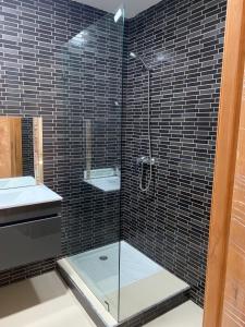 a bathroom with a glass shower with a sink at La Remaz 35 in El Jadida