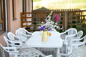 a white table with white chairs and flowers on a patio at Rekreace na Lipně in Frymburk