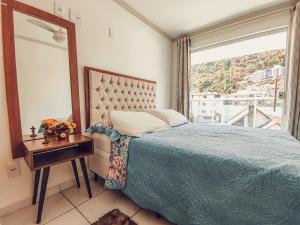 - une chambre avec un lit et une grande fenêtre dans l'établissement Hospedagem Stein - Apartamento 201, à Domingos Martins
