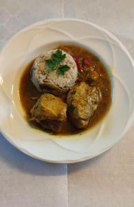 un piatto di cibo con carne e riso su un tavolo di Chambre d'hôtes a Beaumont-Pied-de-Boeuf