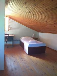 Cama en habitación con techo de madera en Zephyr Guest House, en Lefokastro