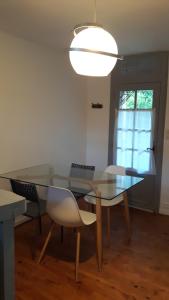ein Esszimmer mit einem Glastisch und Stühlen in der Unterkunft Charmante maison Lotoise in Bretenoux