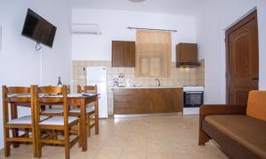 uma cozinha e sala de jantar com mesa e cadeiras em Christina Apartments em Kissamos