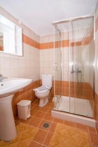 a bathroom with a shower and a toilet and a sink at Christina Apartments in Kissamos